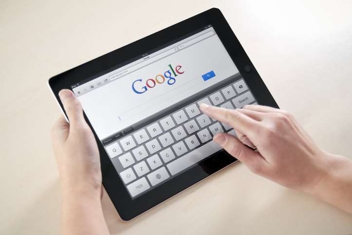 Woman's hands Googling on electronic device